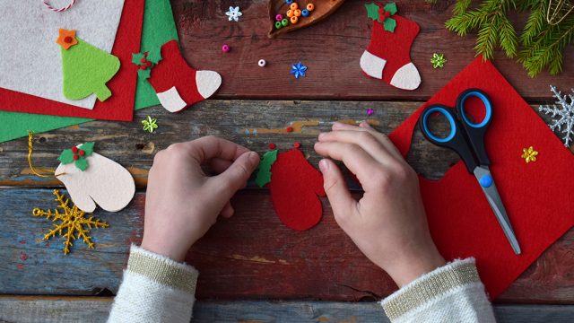 Making of handmade christmas toys from felt with your own hands. Children’s DIY concept. Making xmas tree decoration or greeting card. Step 3. Decorate the toy