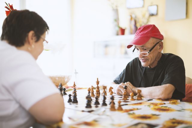 Seniors Playing Chess In The Nursing Home